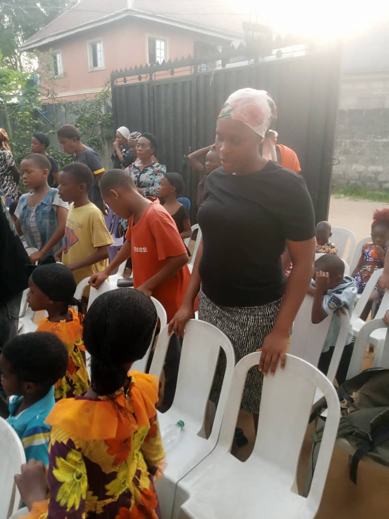 Families and children gathered together in prayer at the outreach