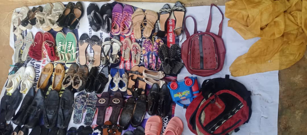 Shoes, sandals, and bags laid out for community members